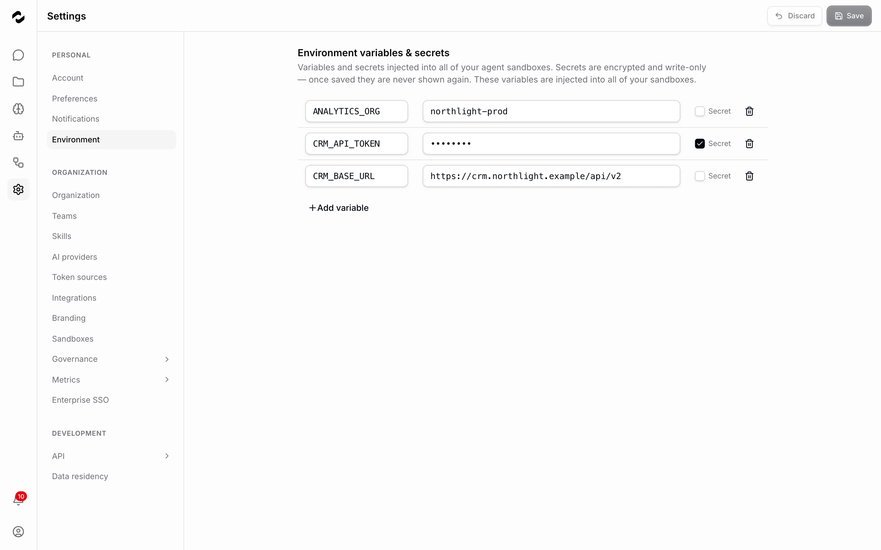 The Environment settings page listing three saved entries — ANALYTICS_ORG and CRM_BASE_URL with their values in plain sight, and CRM_API_TOKEN masked as dots with its Secret box ticked — above an Add variable action.